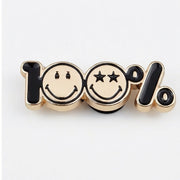 Metallic pin with smiley faces and '100%' text on a white background